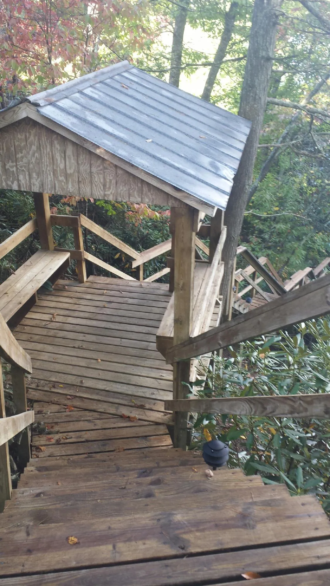 Metal roofed shelter over wooden steps on a wooded walkway — Skylight Repair & Installation work by our crew in Lanesborough
